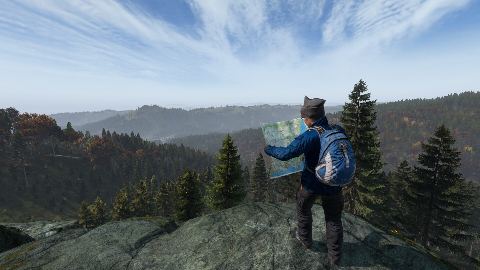 A survivor with a backpack surveys Chernarus from a ridge.