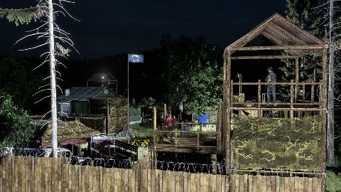 A watchtower and fence base beside a barn.