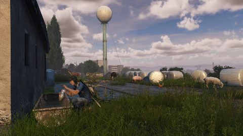 A survivor crouches in grass watching the Green Mountain radio tower.